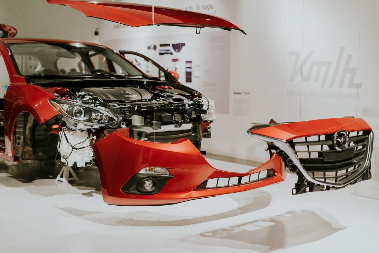 Crafting Captivating Headlines: Your awesome post title goes here Explore a detailed view of a partially disassembled red Mazda 3 showcased at an auto exhibition.